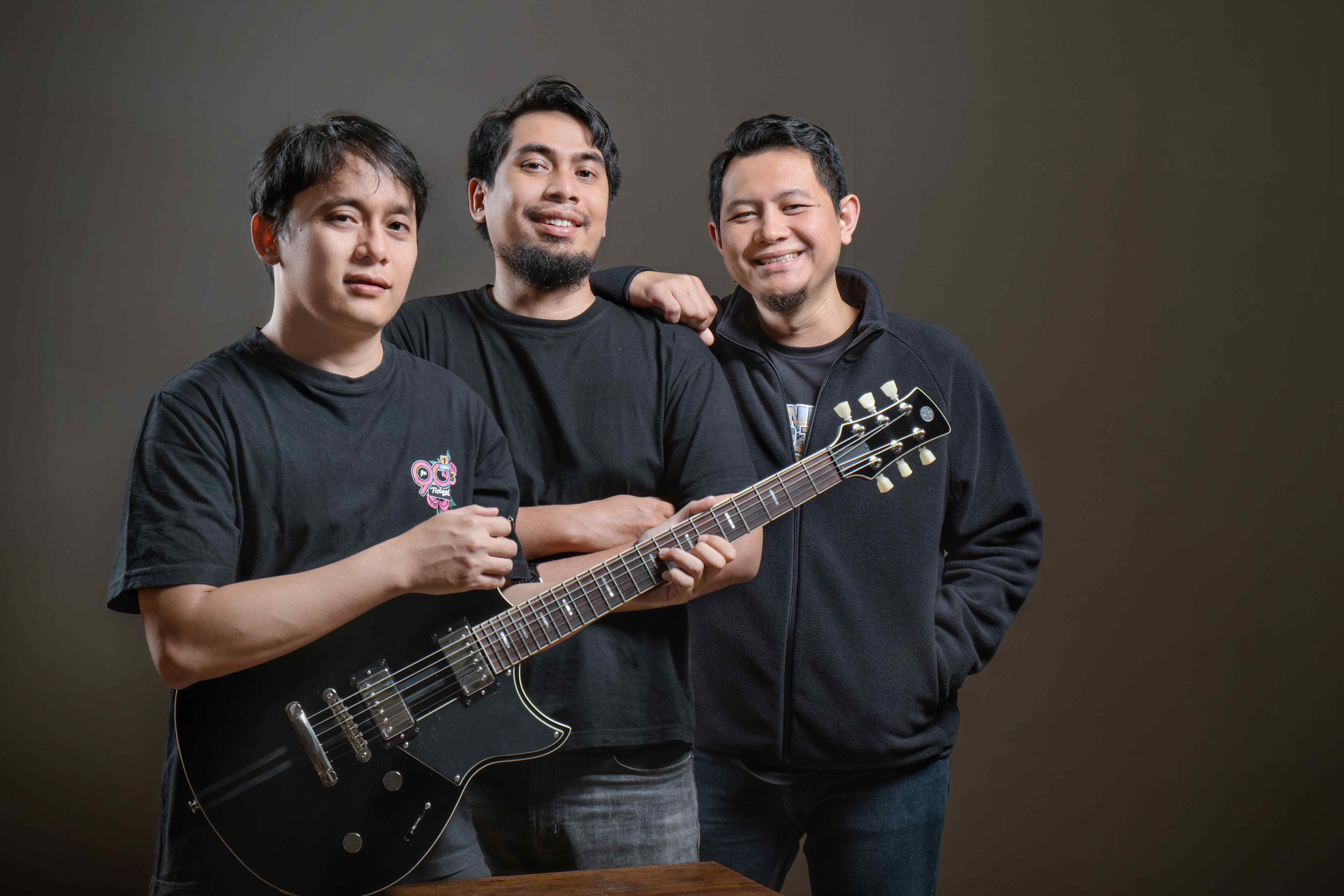 Teeloe Band tersenyum memegang gitar di studio