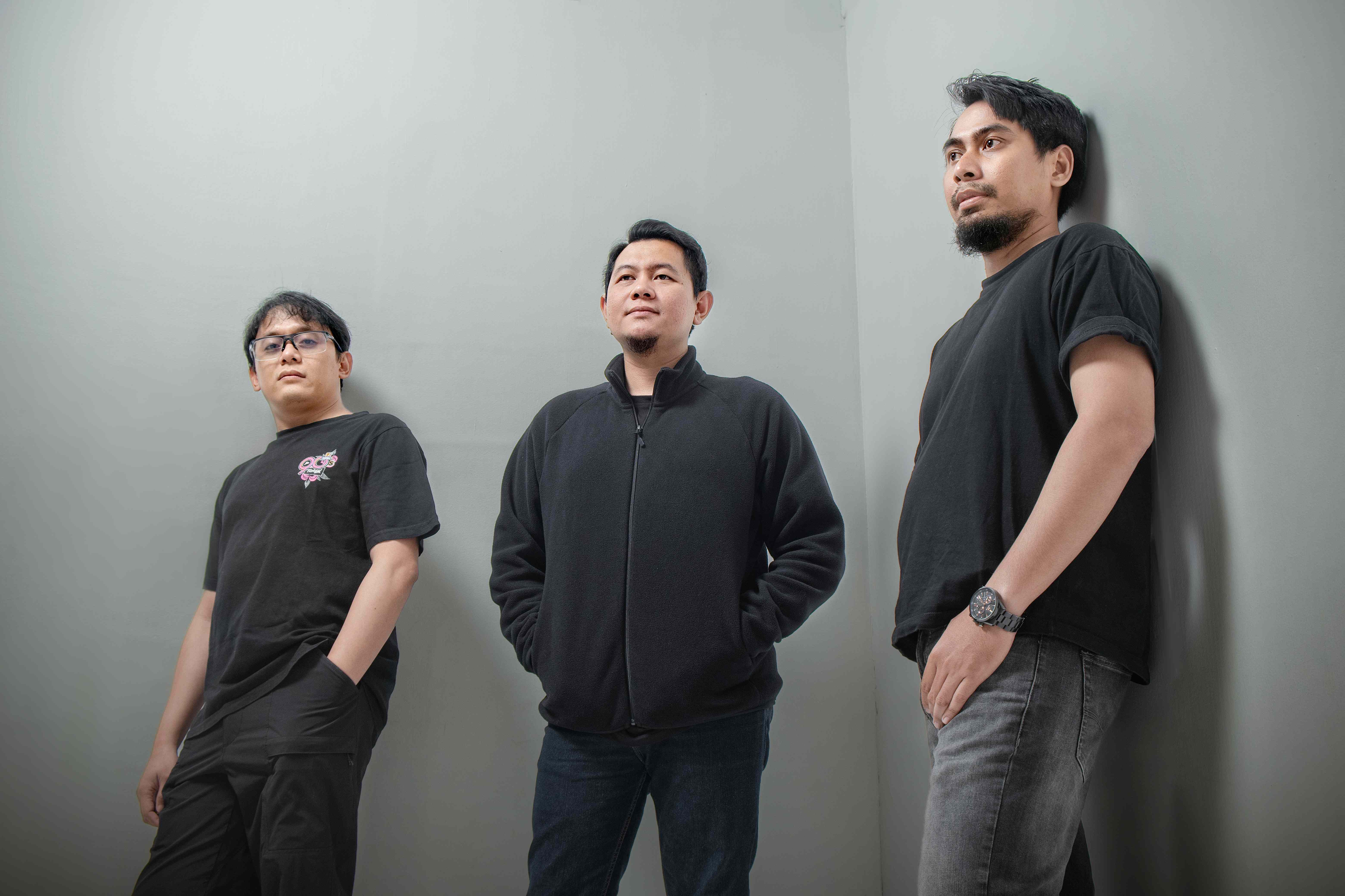 Teeloe Band bersandar di dinding abu-abu